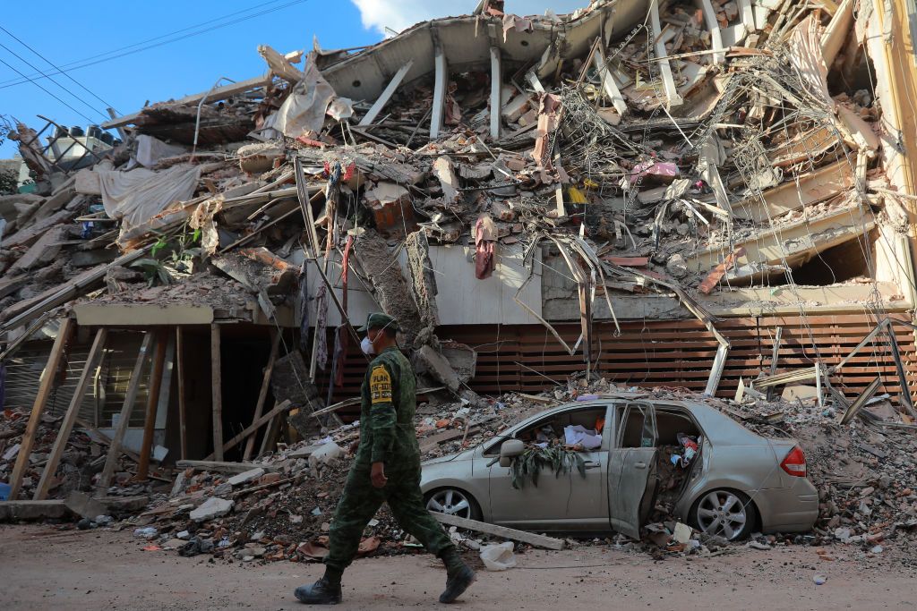 MEXICO CITY, MEXICO - SEPTEMBER 19: A military police guards a building knocked down by a magnitude 7.1 earthquake that jolted central Mexico damaging buildings, knocking out power and causing alarm throughout the capital on September 19, 2017 in Mexico City, Mexico. The earthquake comes 32 years after a magnitude-8.0 earthquake hit on September 19, 1985. (Photo by Hector Vivas/Getty Images)